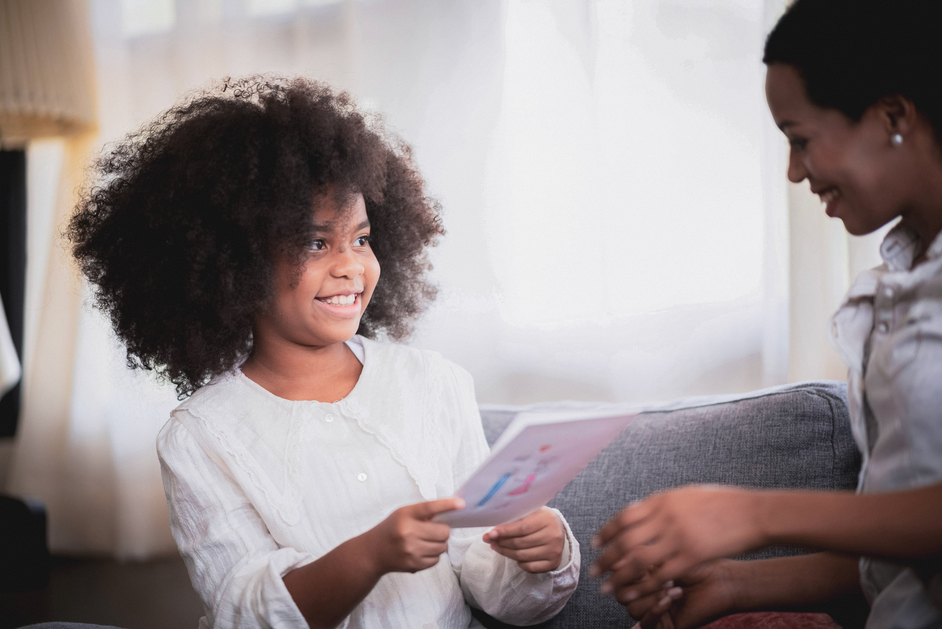 Little girl showing her mom her art