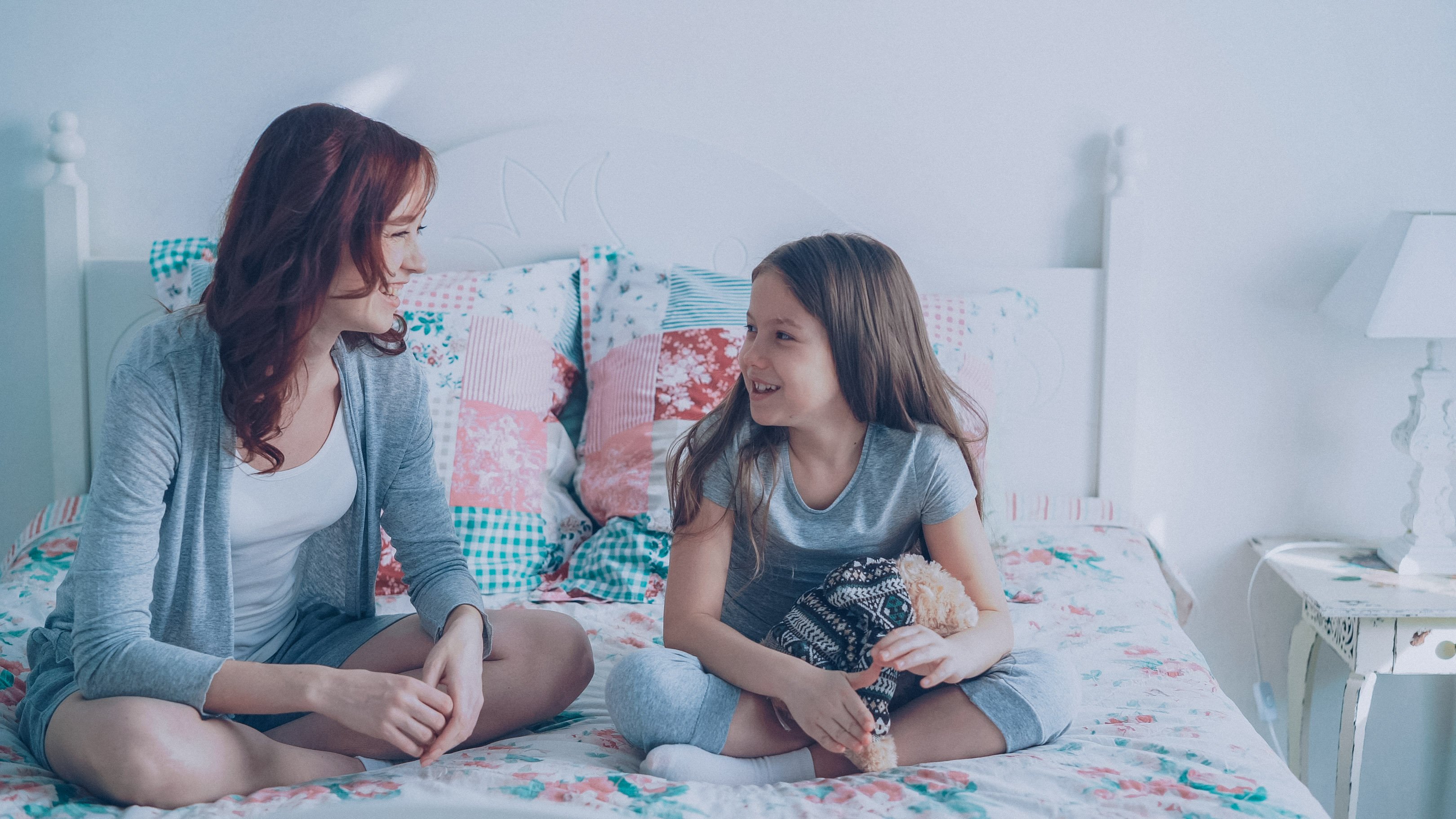 Mom and daughter talking on a bed