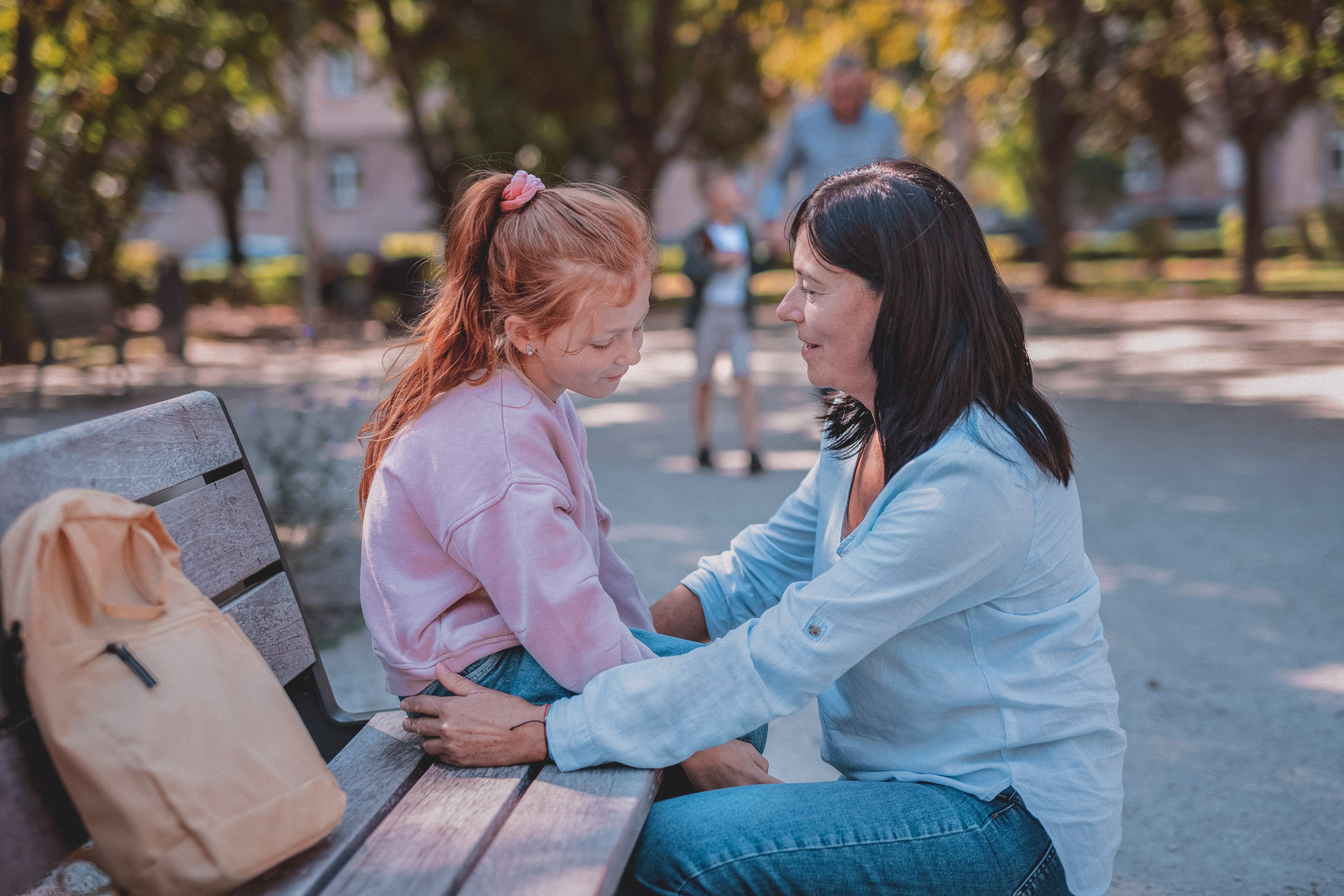 Mom talking to her daughter about bullying at the park