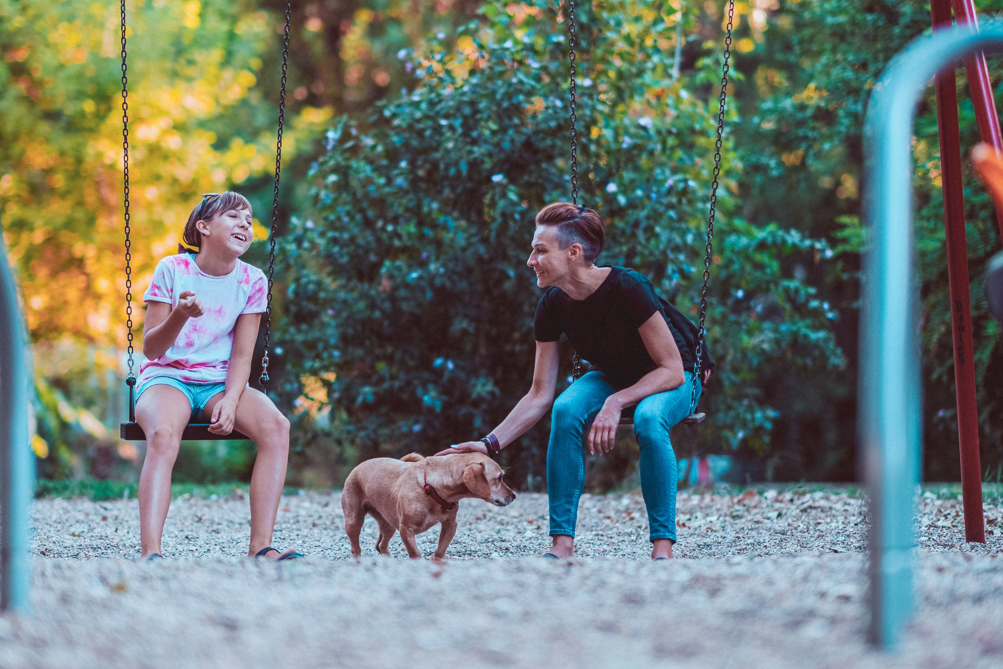 Parent and kid swinging on a swing set