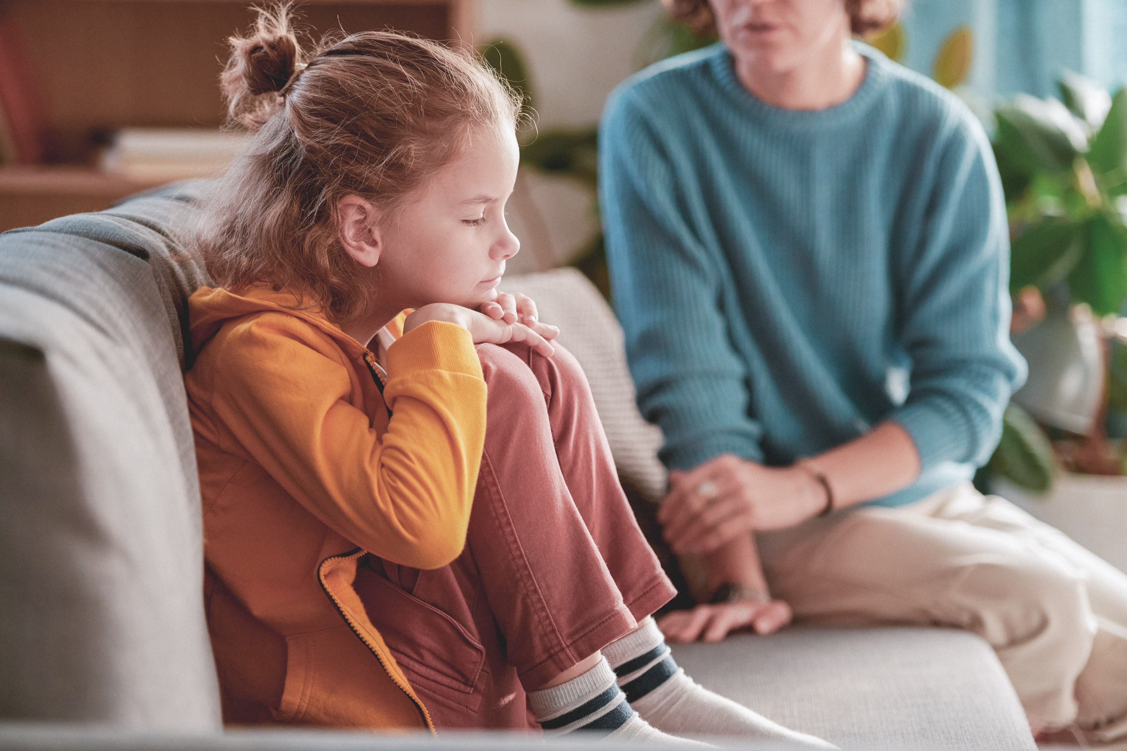 Upset child on couch with parent