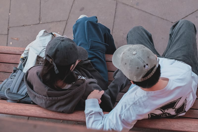 Teen couple talking on a bench