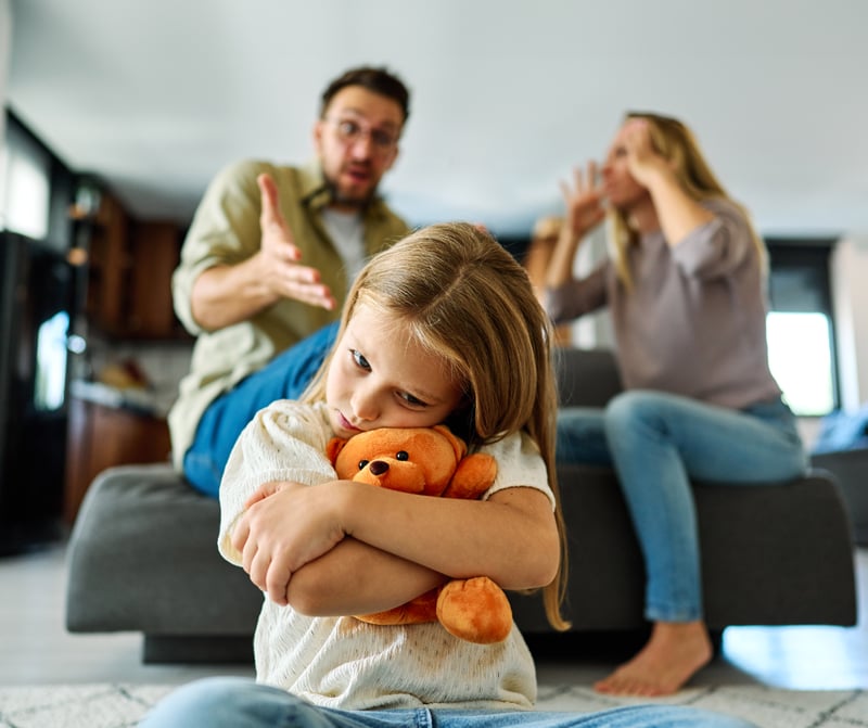 An unhappy girl experiencing unhealthy family dynamics as her parents argue