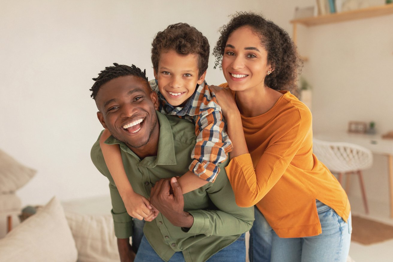 Dad and mom hugging child as a family