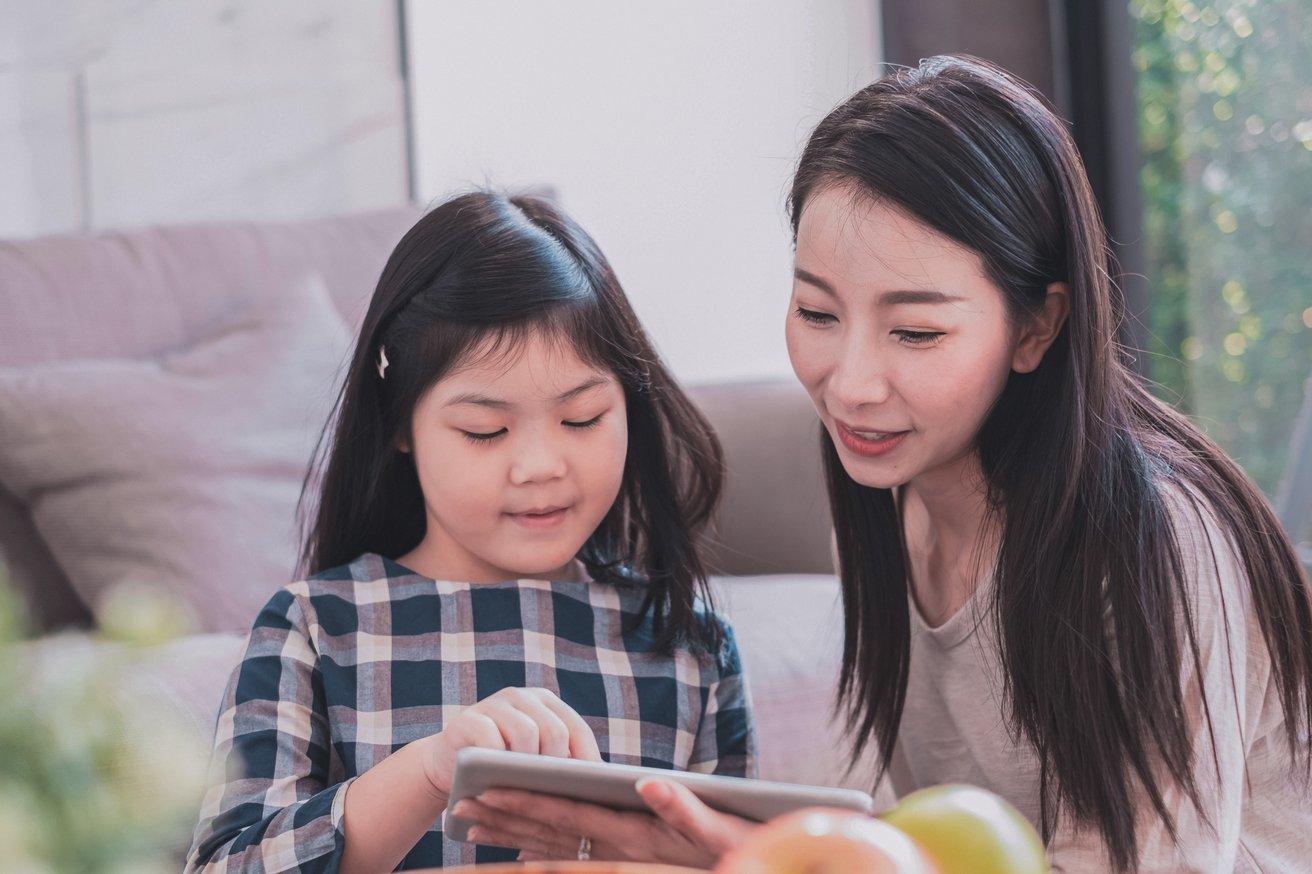 Daughter and mom playing together on an iPad