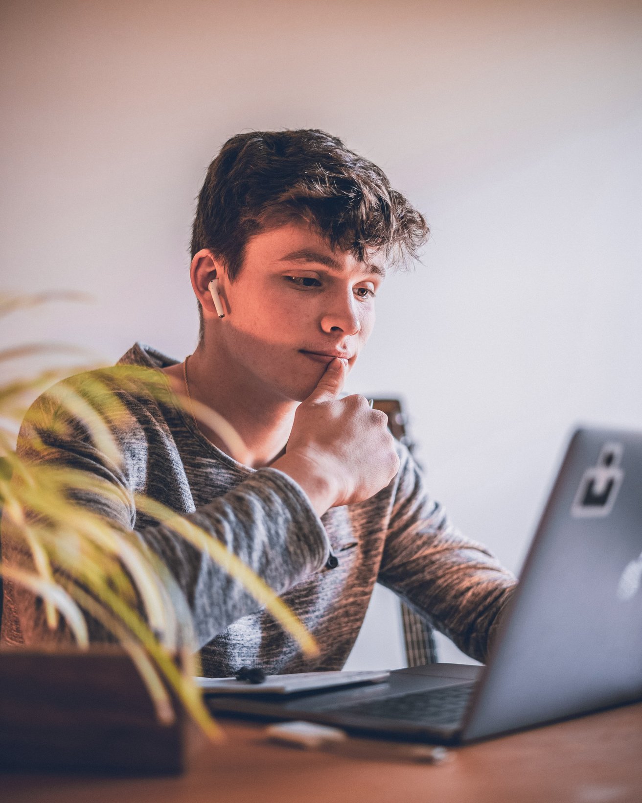 teenage boy with earbuds in at the computer