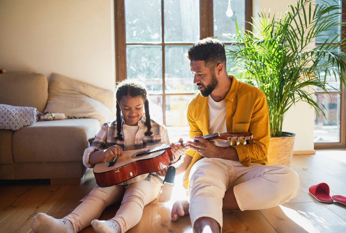 Father showing daughter guitar