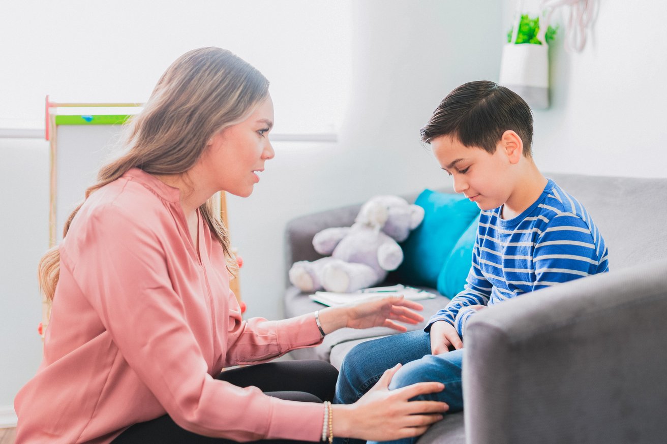 Female therapist talking to a kid in a therapy session