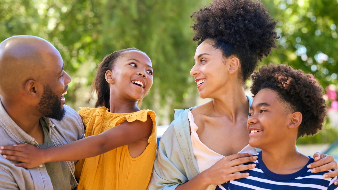 Dad, daughter, mom, and son outside smiling