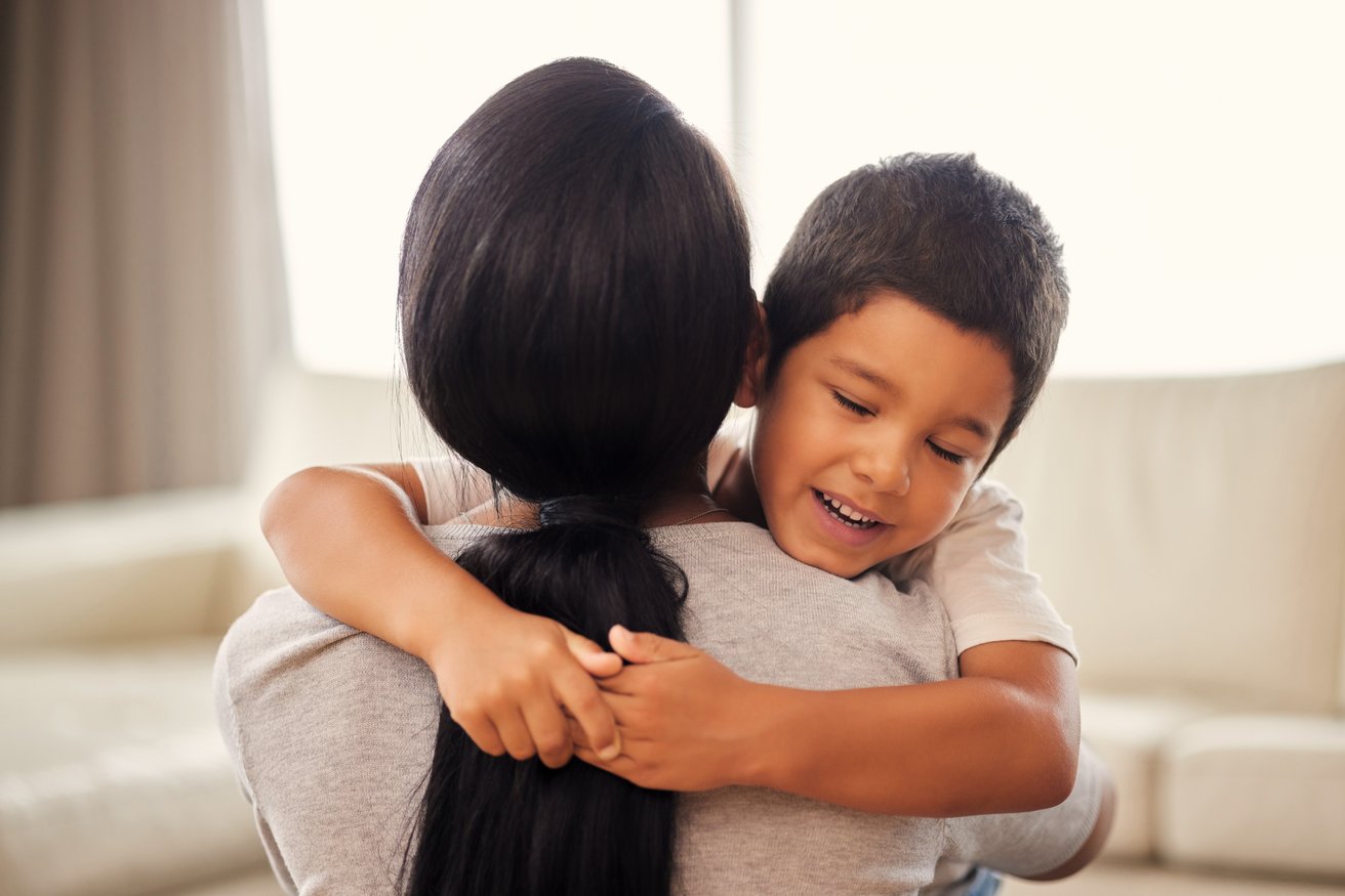 A young boy hugging his mother