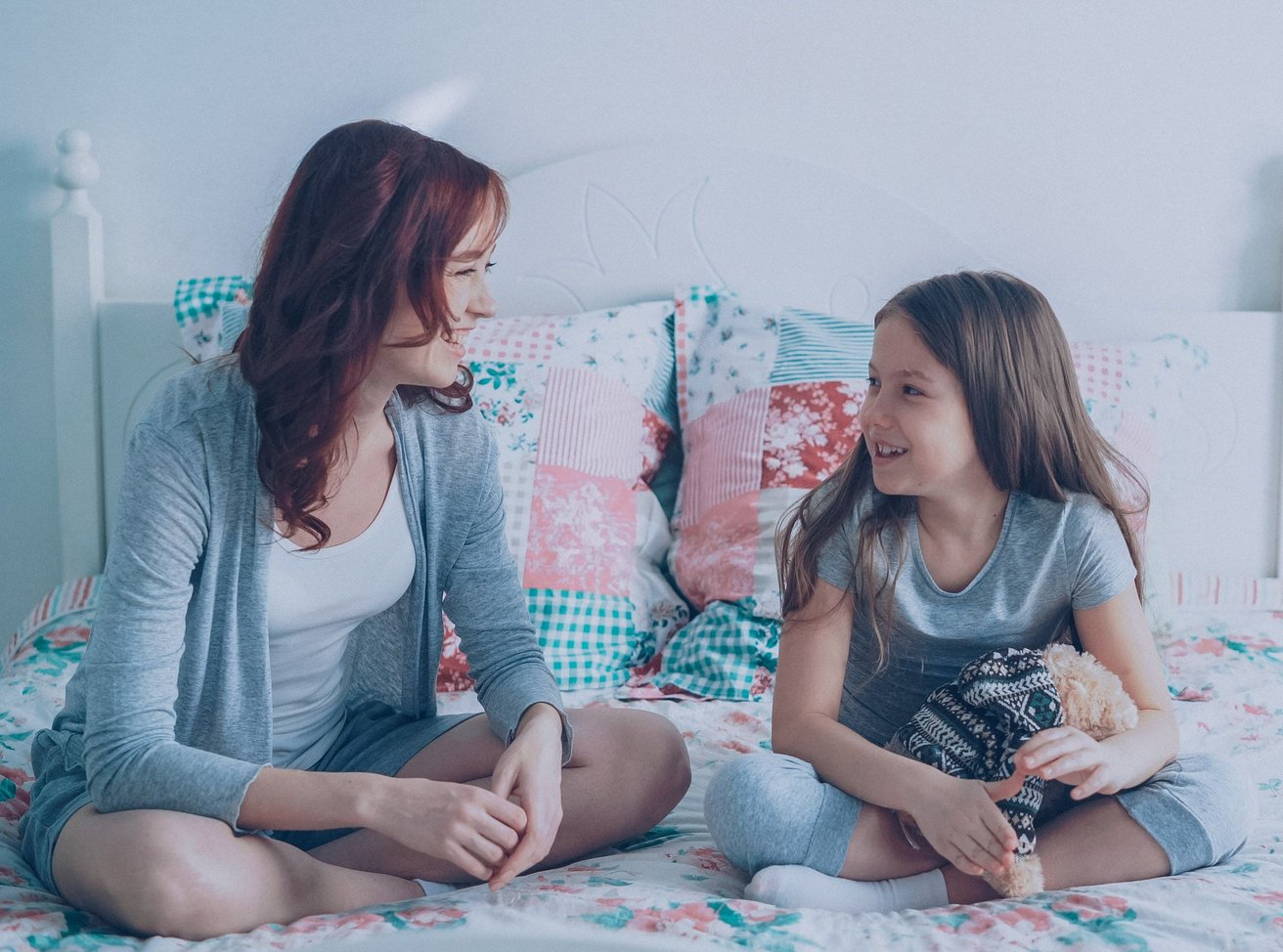Mom and daughter talking on a bed