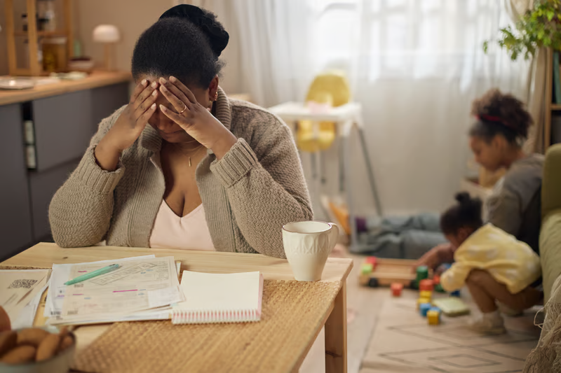 Mom feeling overwhelmed while daughters play in the background