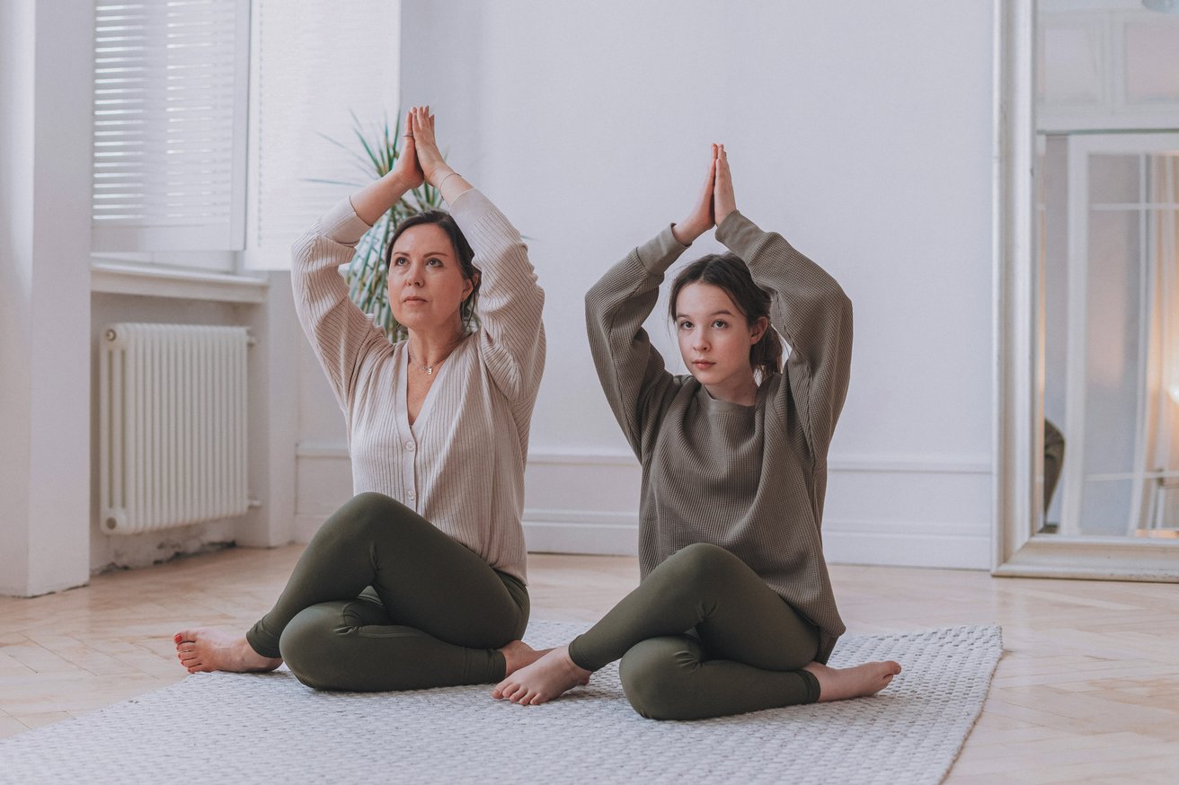 Teen girl and mom practicing yoga