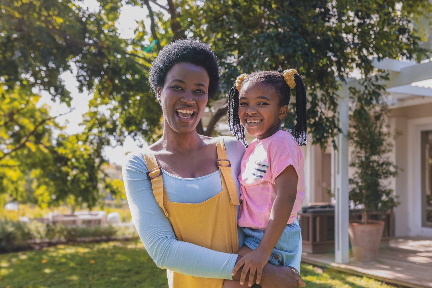 Mom holder her young daughter outside