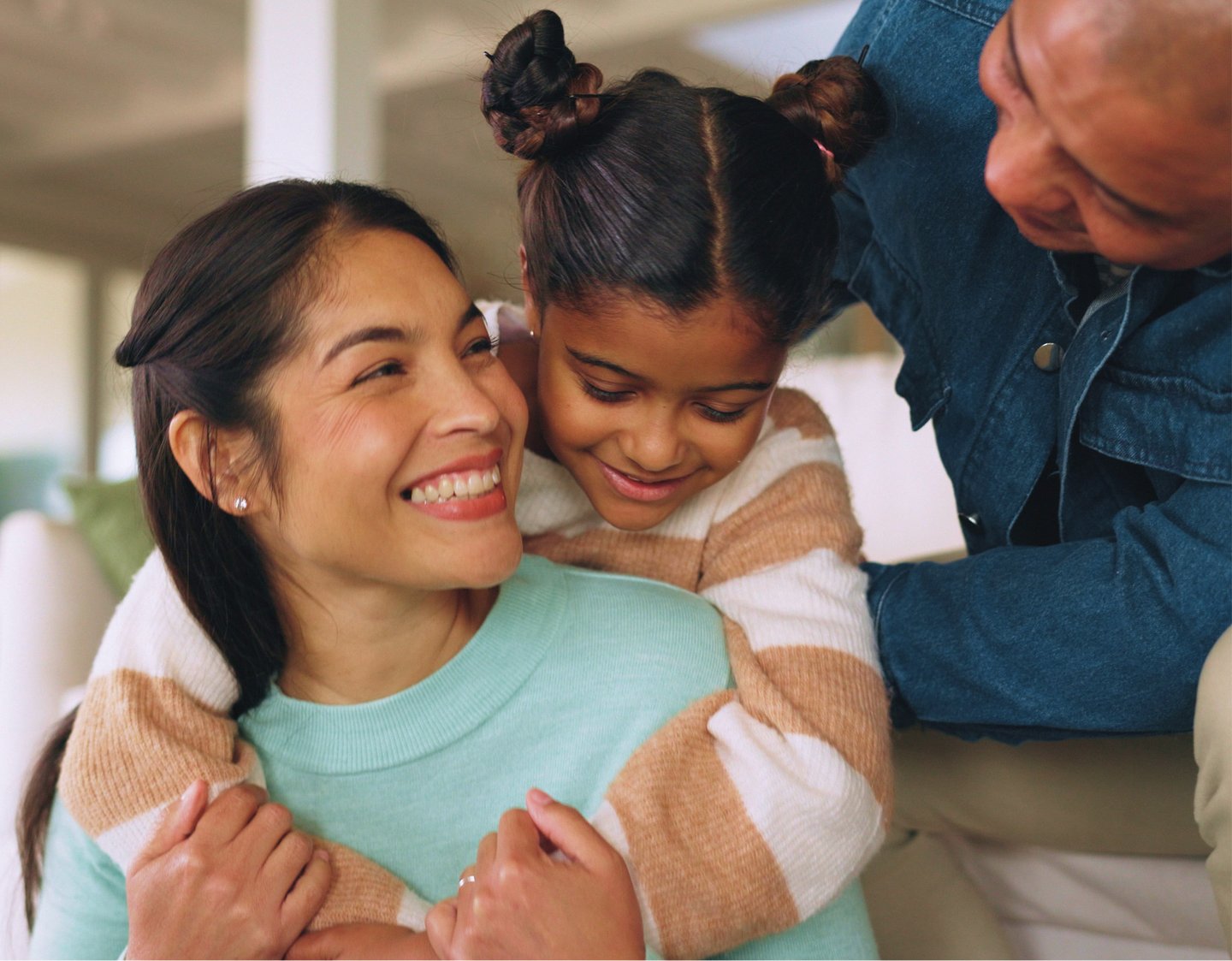 Mom Dad and daughter hugging