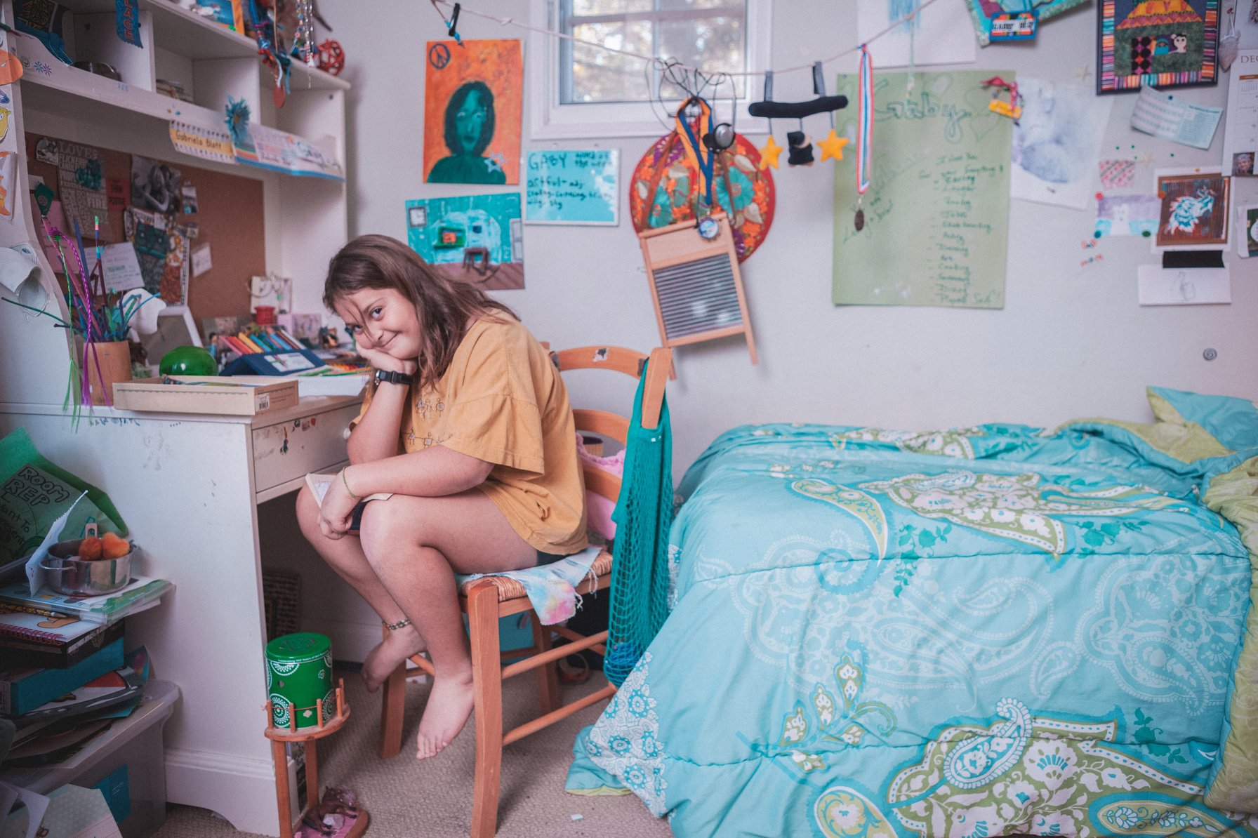 Girl sitting on a chair in her messy room