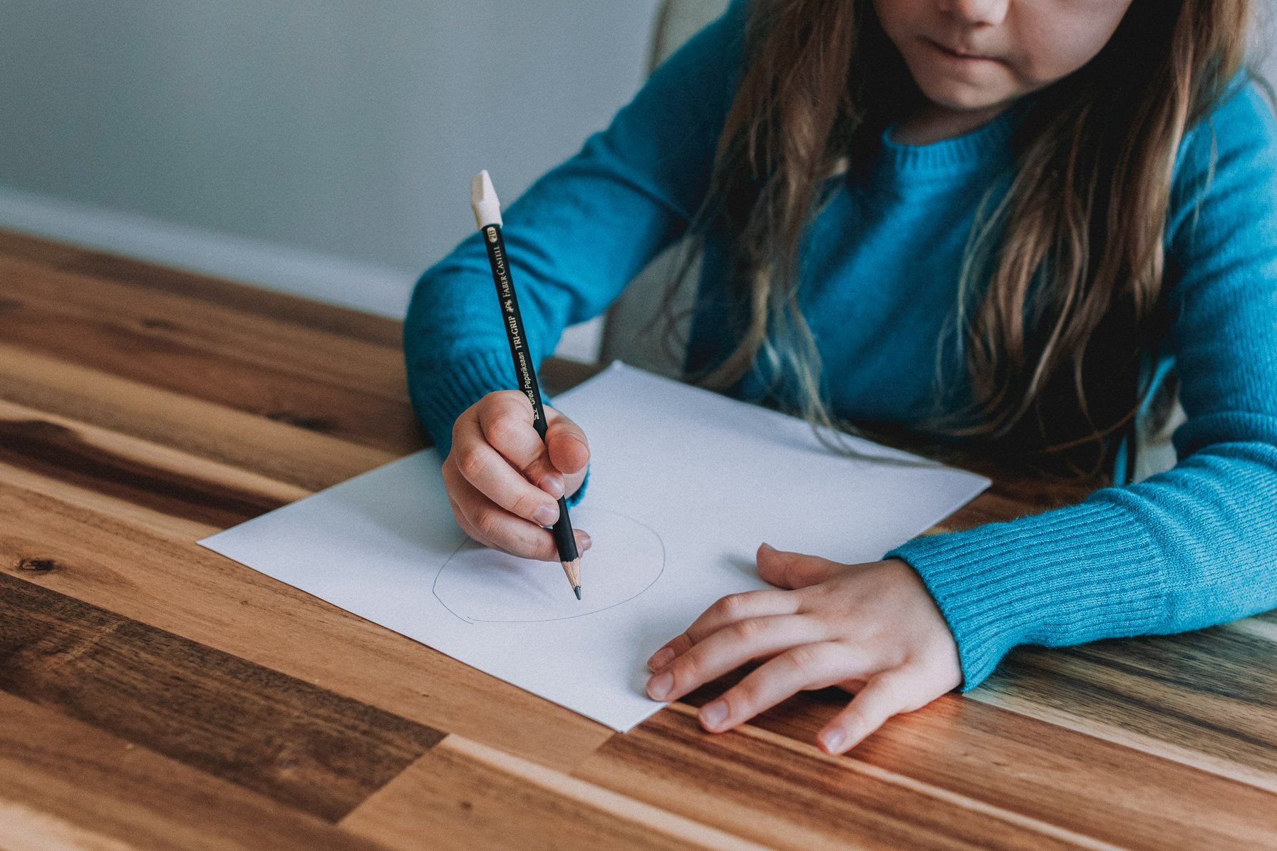Kid drawing on paper with a pencil