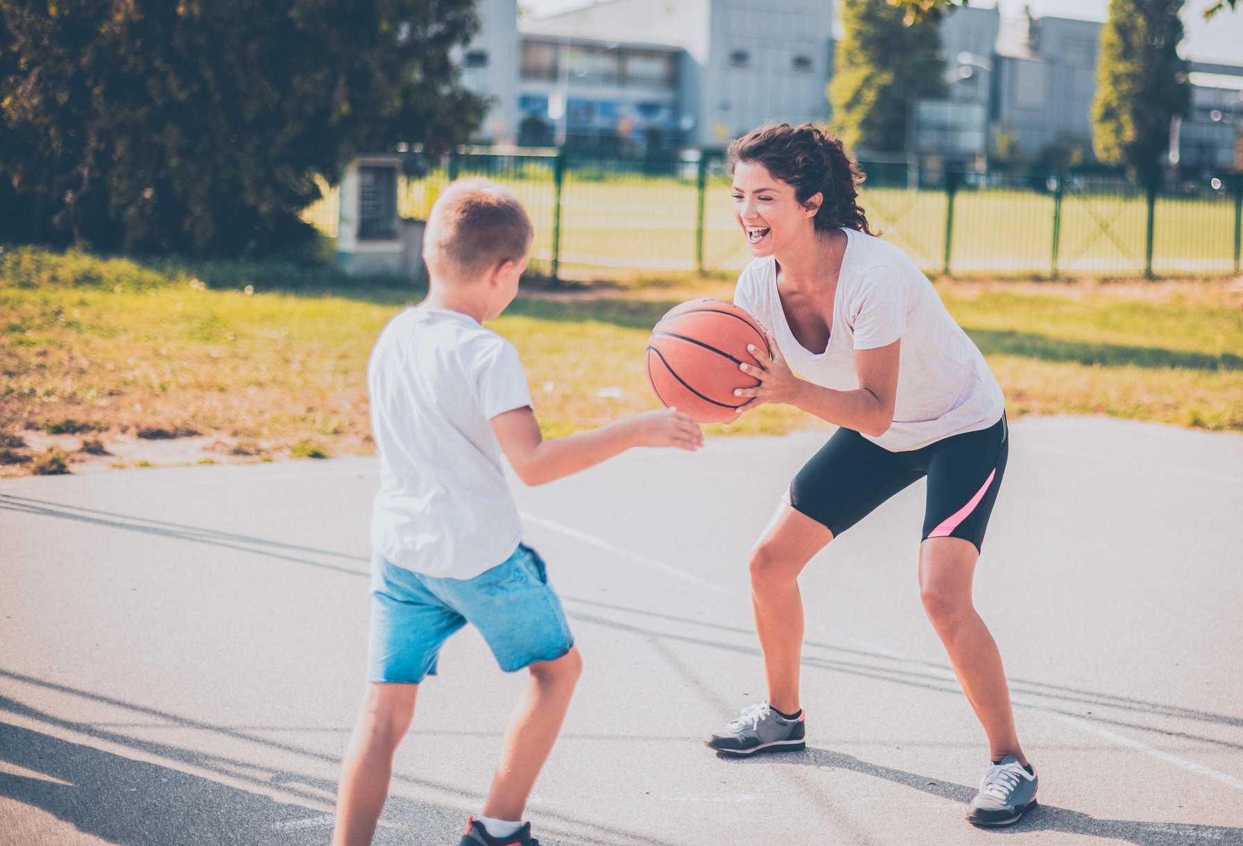 Kids playing basketball with his mom