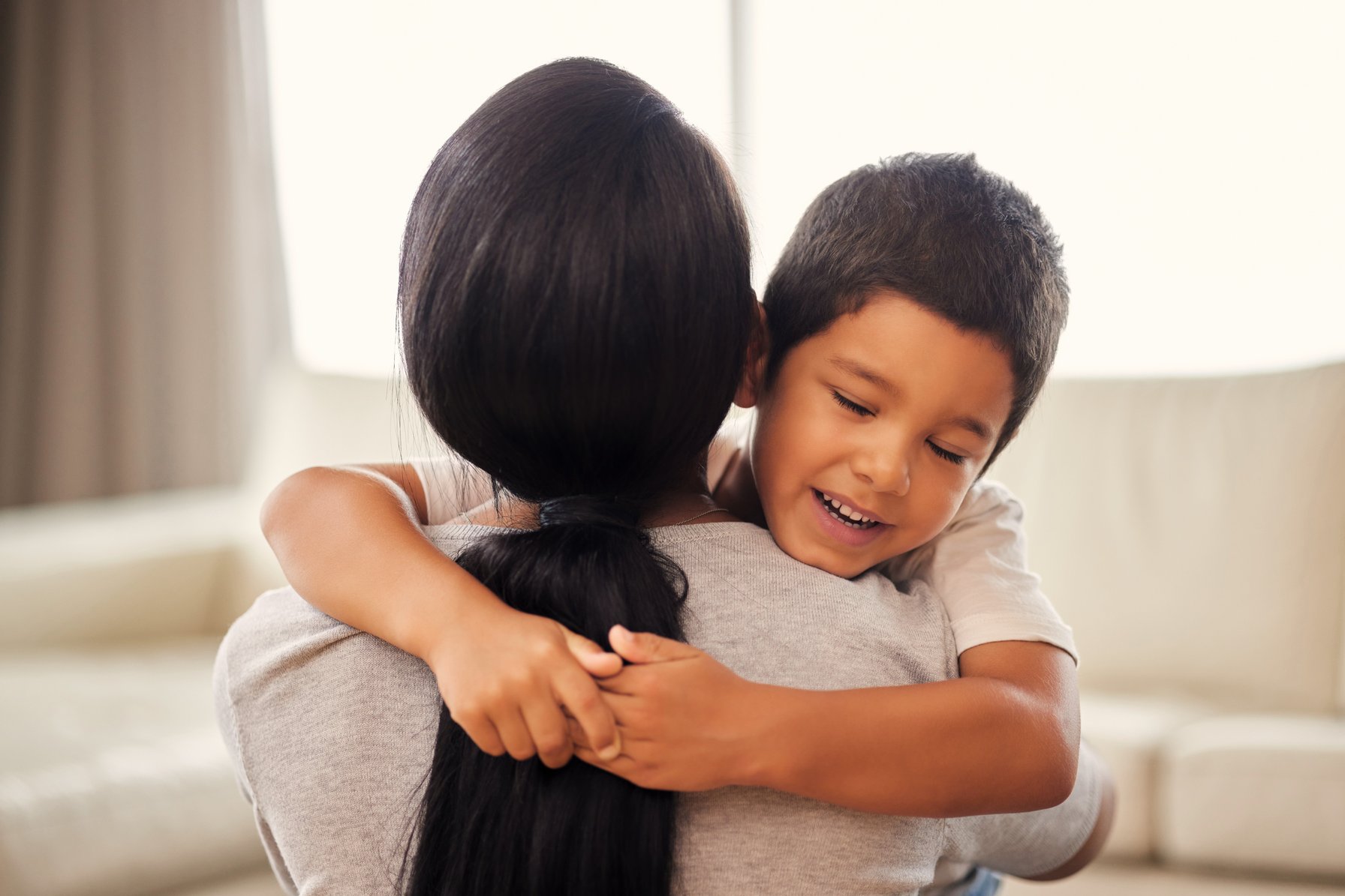 A young boy hugging his mother