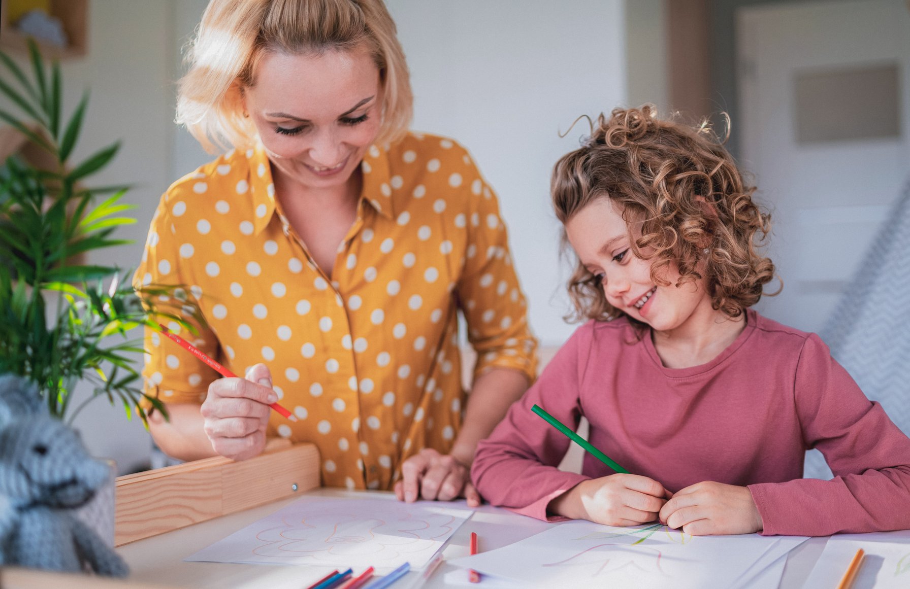 Mom drawing pictures with colored pencils with her daughter