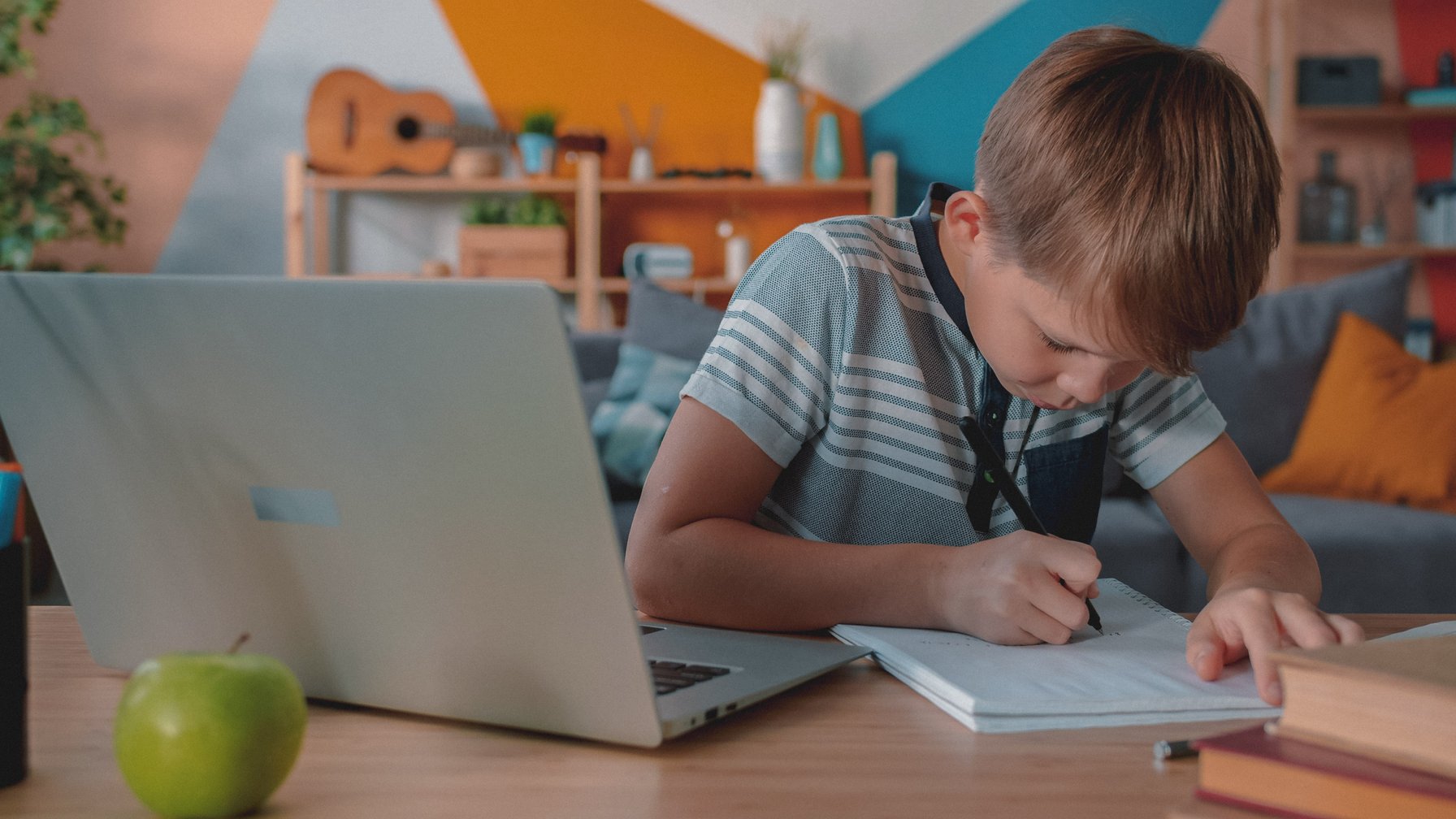 Young boy completing homework in a notebook